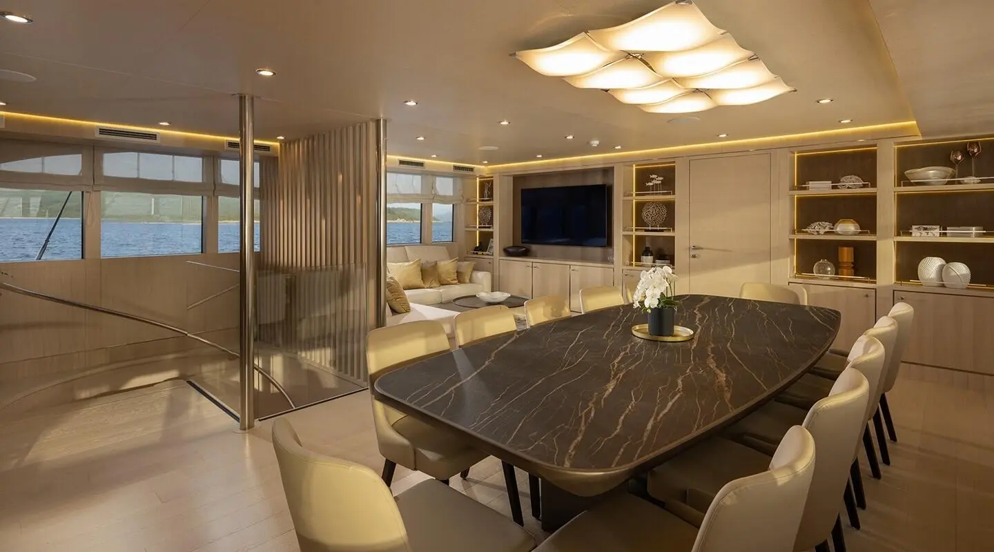 Love Story yacht interior with dining table, seating, and large window views
