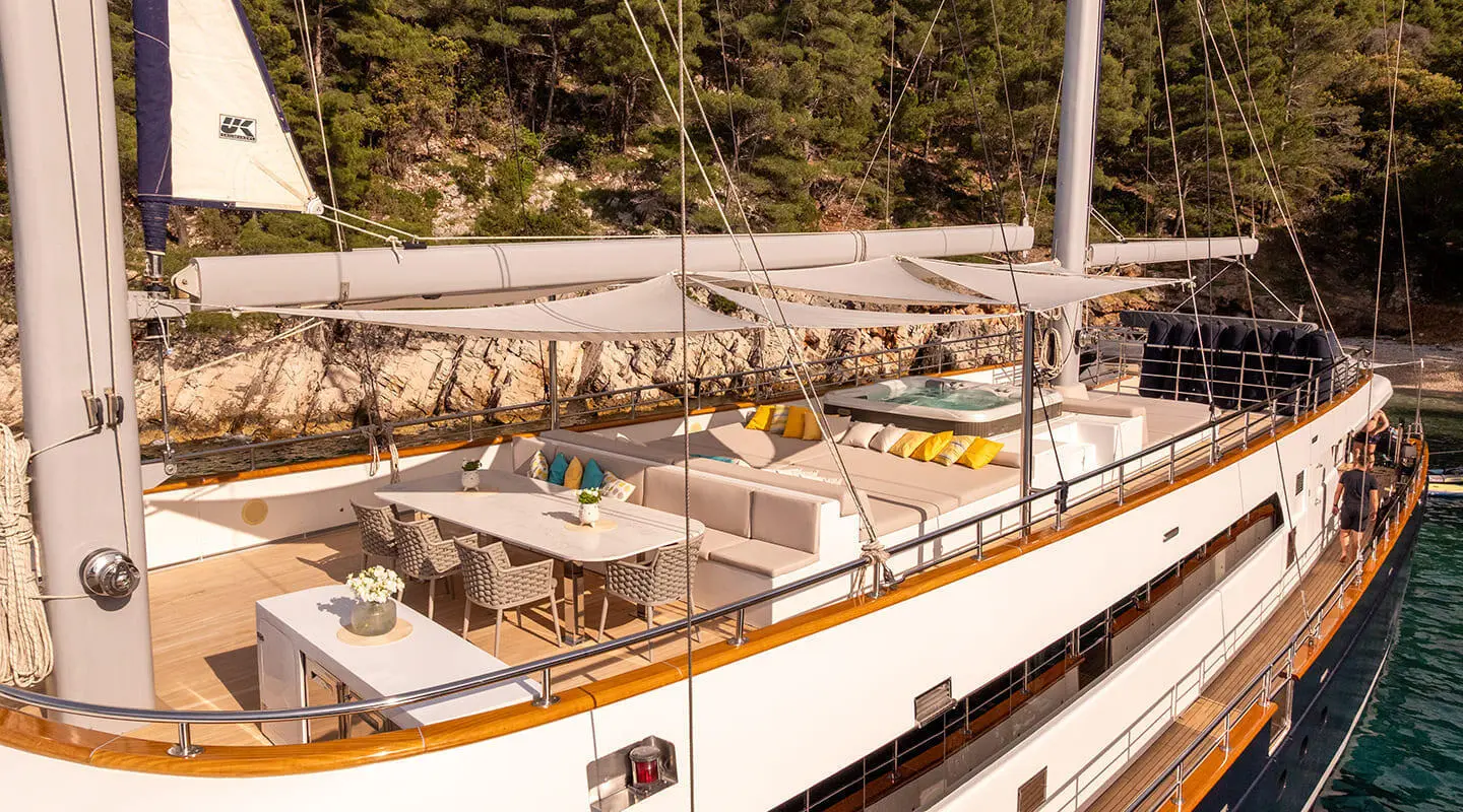 Dalmatino yacht outdoor sundeck with seating and dining area under sunshade
