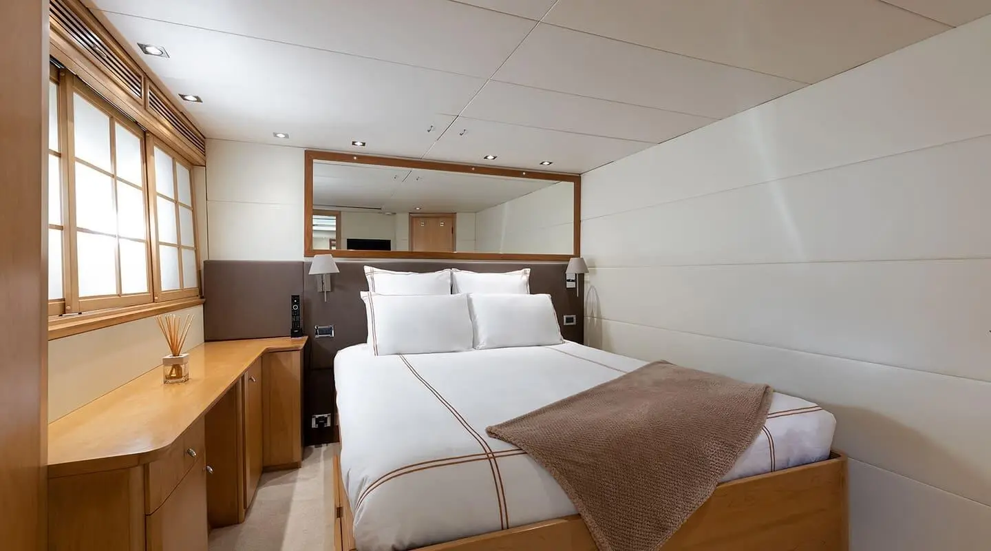 Interior view of a luxury yacht cabin with two twin beds and brown headboard