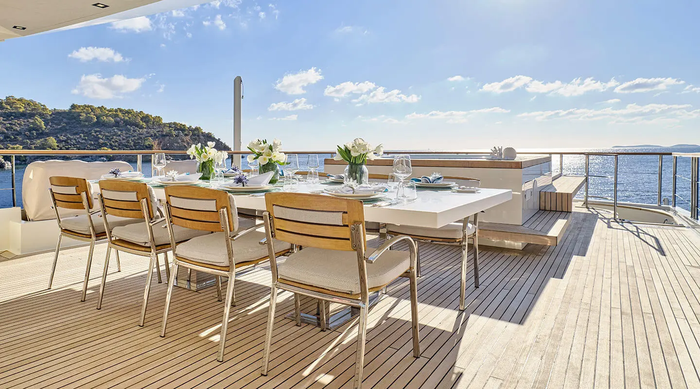 La Pellegrina 1 yacht dining area on deck with wooden table and chairs