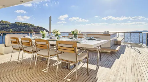 La Pellegrina 1 yacht dining area on deck with wooden table and chairs