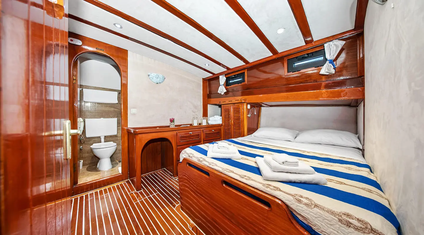 Eleganza yacht interior: wooden deck, blue and white striped cushions, built-in cabinets