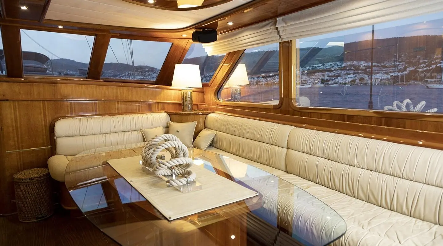 Luxurious sailing yacht interior with cream seating and wood accents at sunset