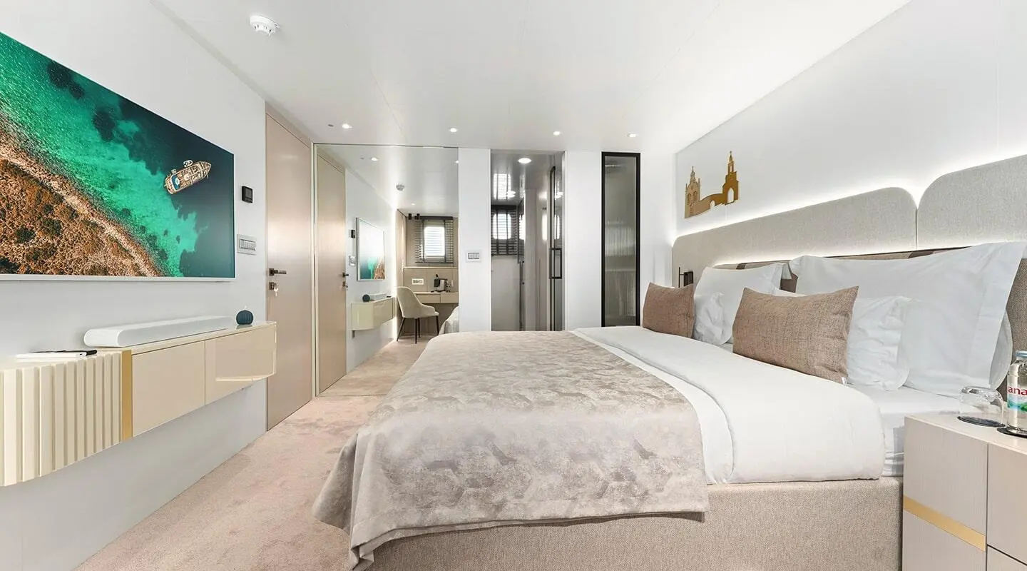 Bedroom interior with large bed, pillows and headboard in a yacht