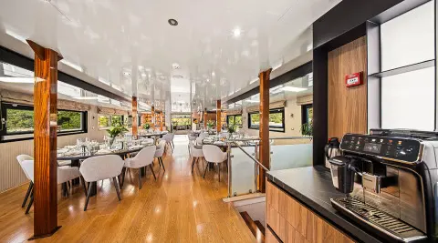 Interior of Karizma yacht saloon with wooden flooring, seating, and tables