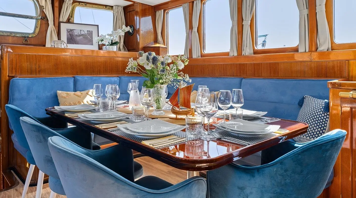 Elegant yacht interior with table set for dining, warm sunset light
