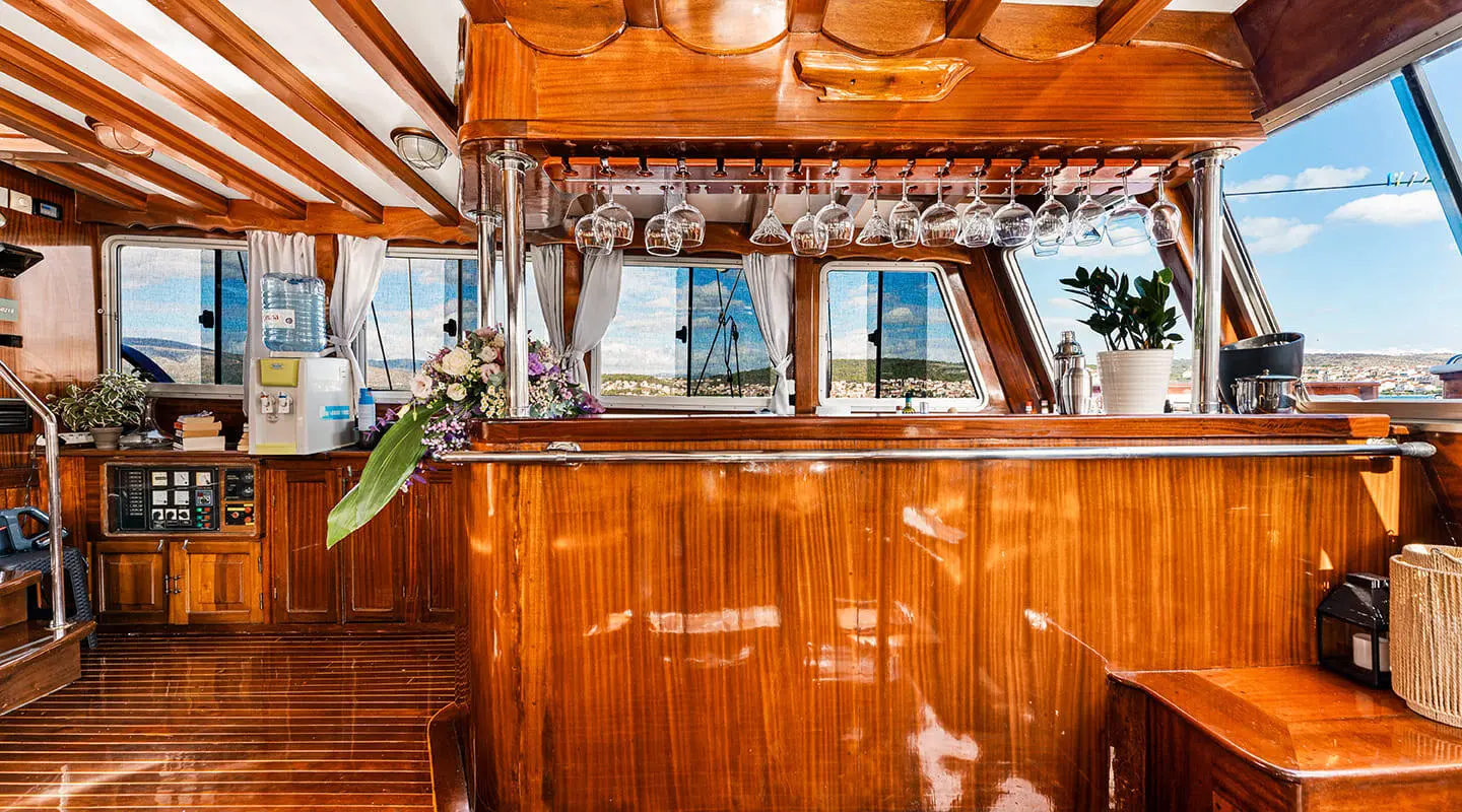 A luxury yacht interior with polished wooden paneling and brass accents at sunset