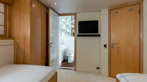 Interior of yacht Brooklyn with bed, wardrobe, and door to balcony
