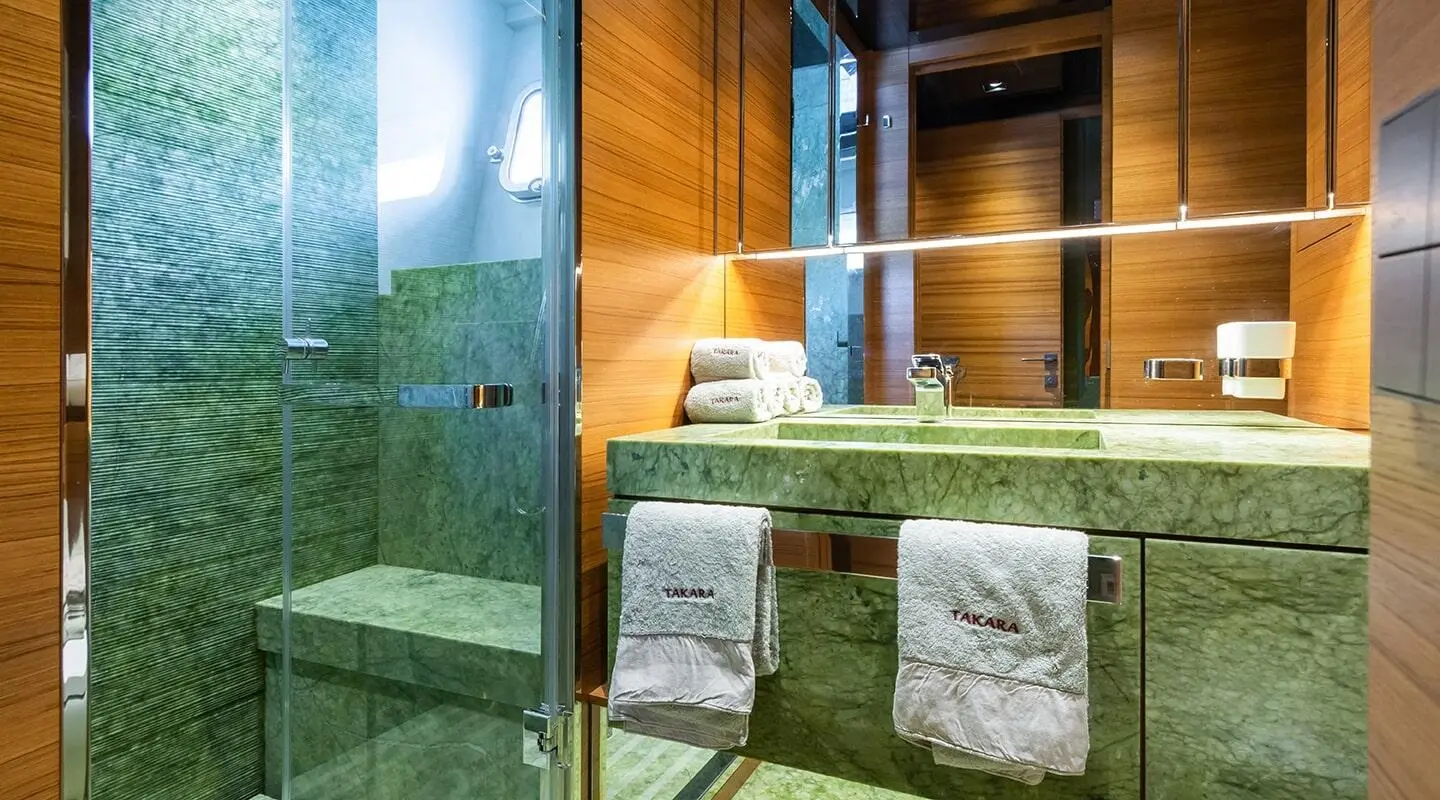 Takara One motor yacht bathroom with stone sink and glass shower enclosure