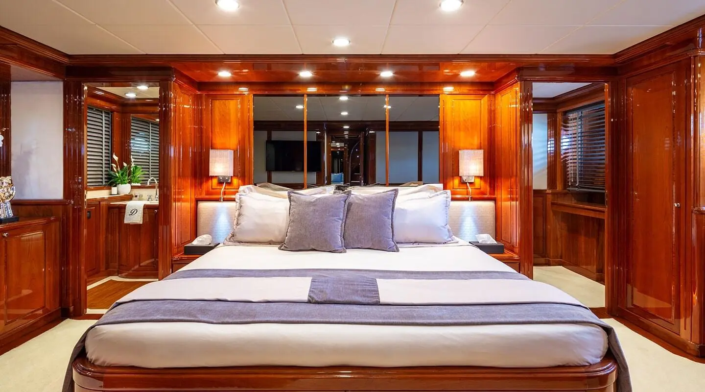 Yacht Divine master cabin with large bed, curtains, wooden cabinetry, and soft lighting