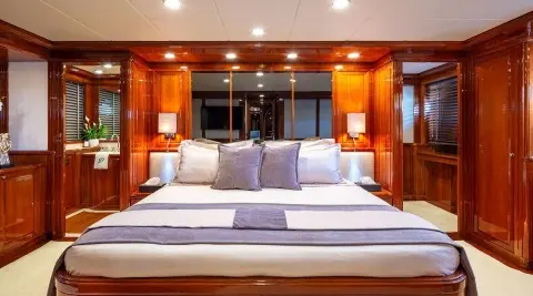 Yacht Divine master cabin with large bed, curtains, wooden cabinetry, and soft lighting
