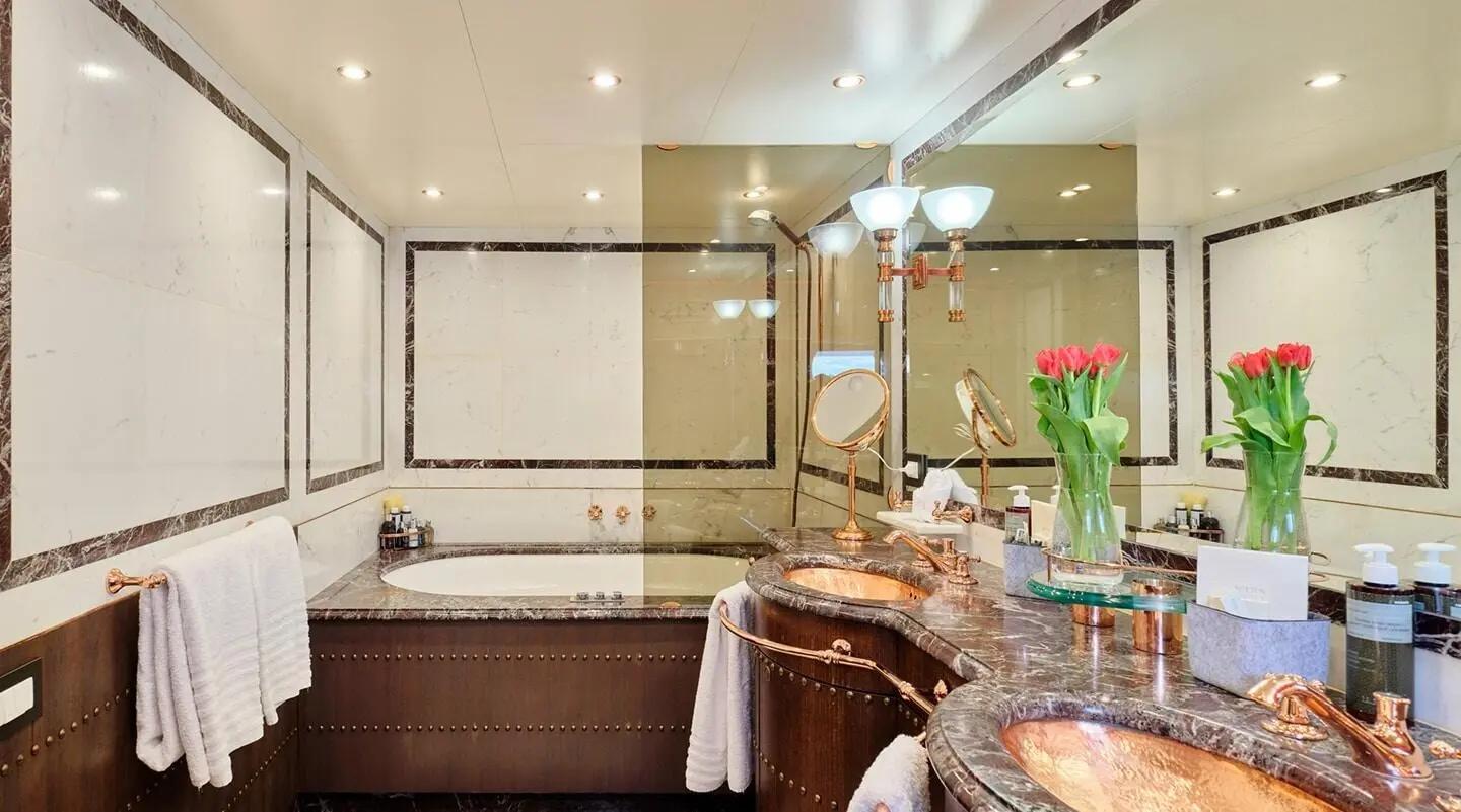 Mobius motor yacht in a cabin with a bed, porthole, and polished wood accents
