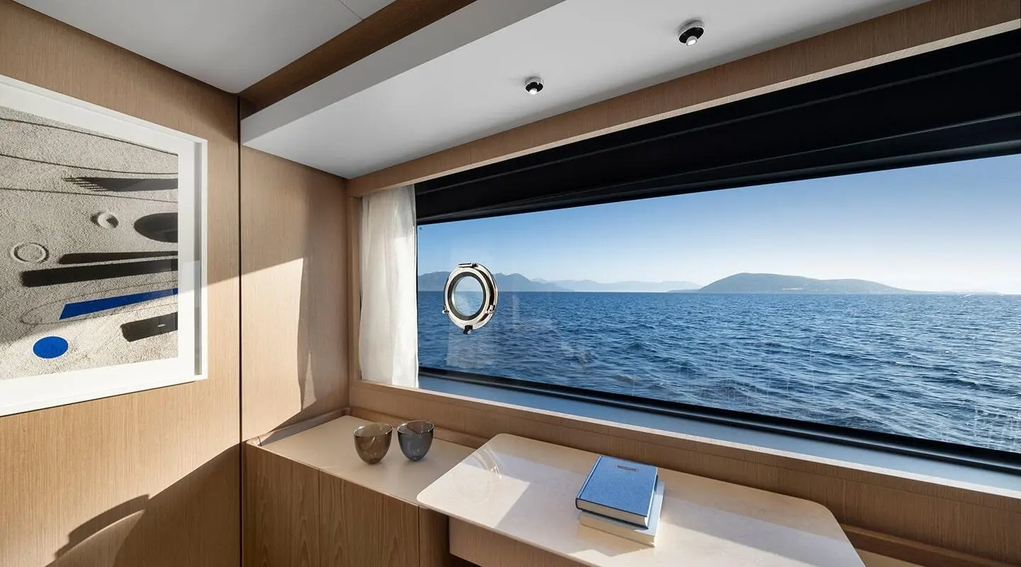View from yacht cabin porthole: calm blue sea and distant horizon