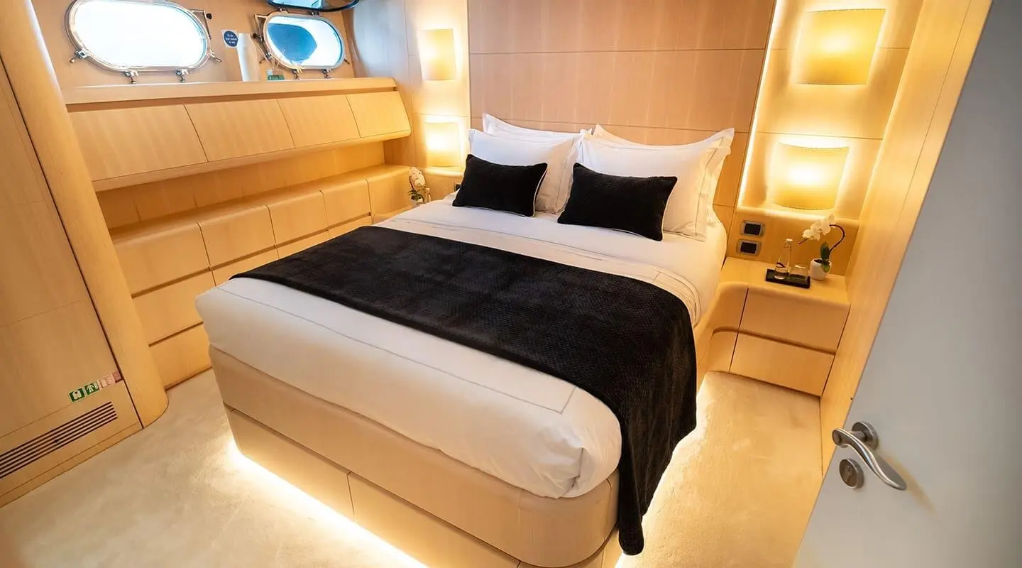 Pareaki II motor yacht double cabin interior with bed and warm lighting