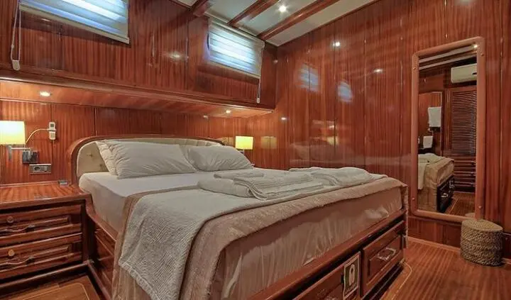 Master cabin with king bed, wooden paneling, ensuite visible, Lycian Queen