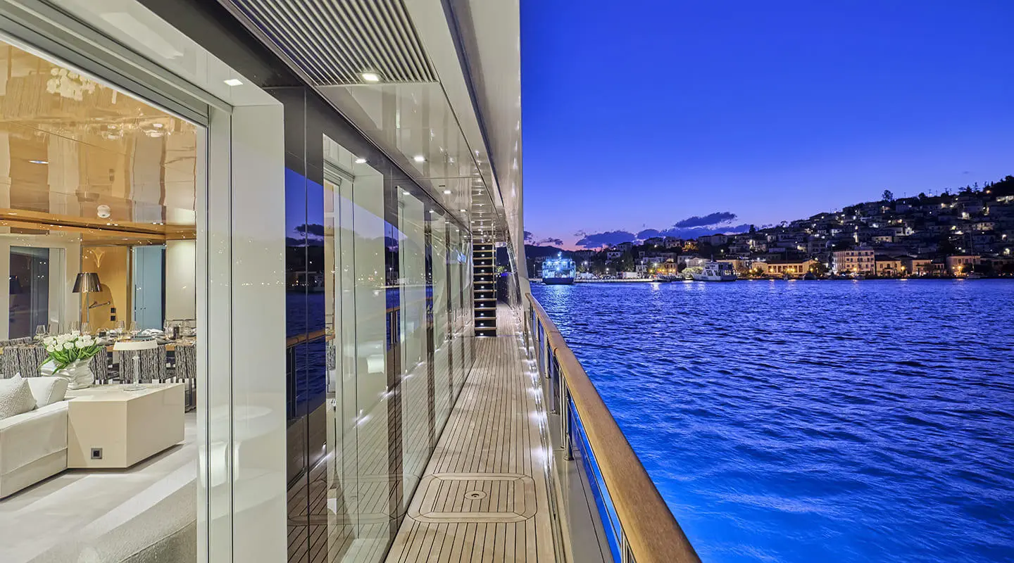 Side deck of La Pellegrina 1 yacht, railing and blue sea beside the hull