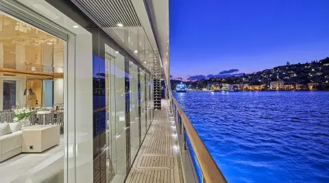 Side deck of La Pellegrina 1 yacht, railing and blue sea beside the hull