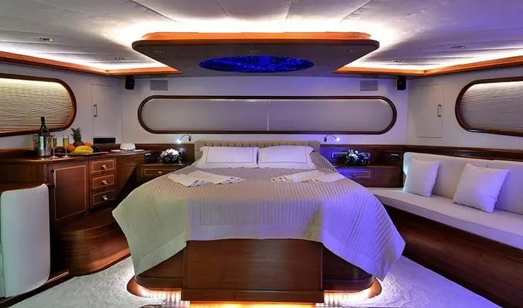 Dolce Mare master cabin interior with bed, nightstands, and seating