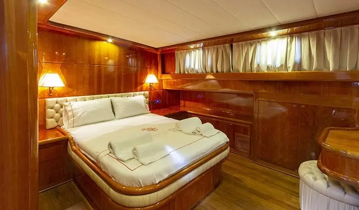 Silver Moon yacht cabin with large white bed and wooden interiors
