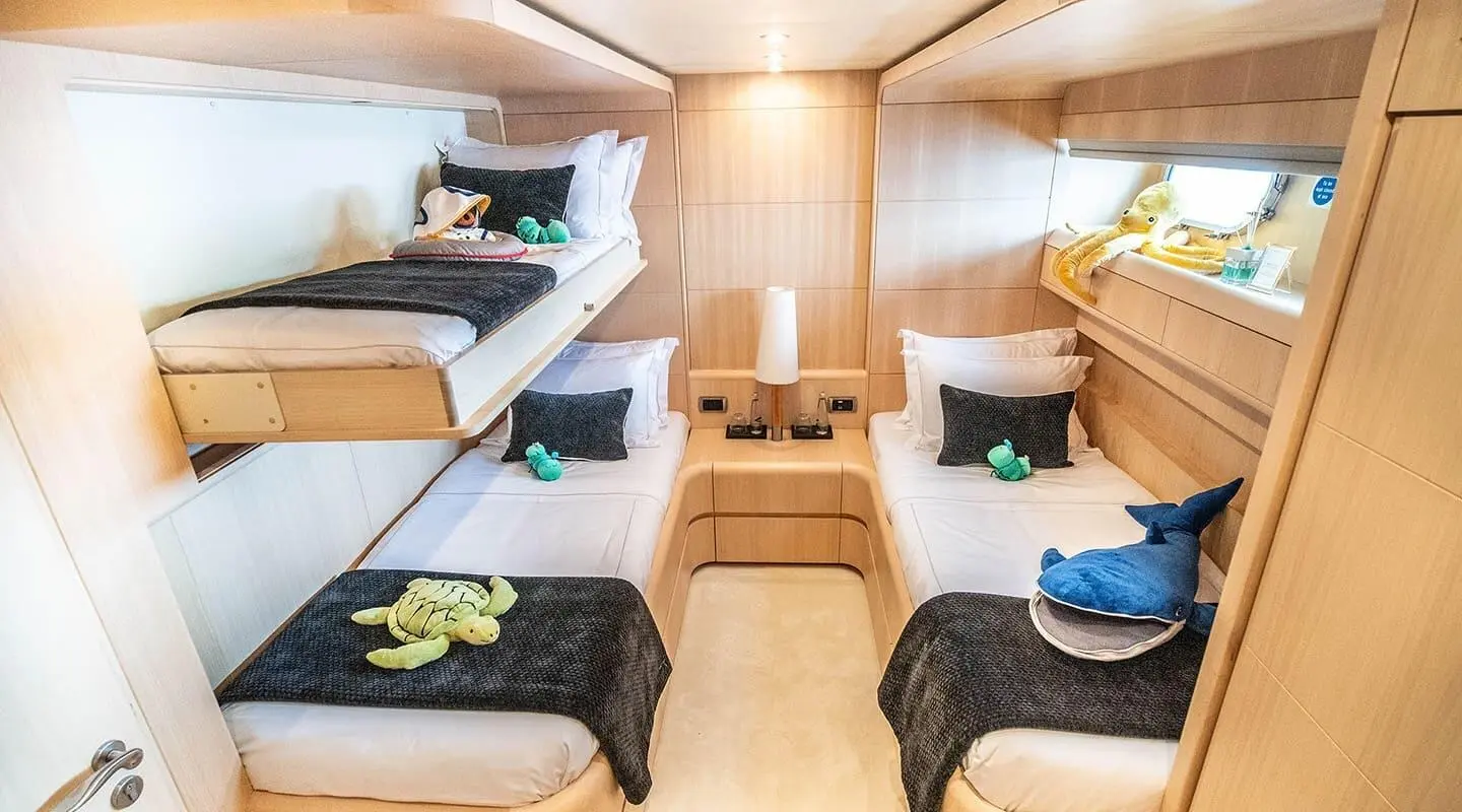 Pareaki II yacht interior twin cabin with two single beds, cushions, and bedside table