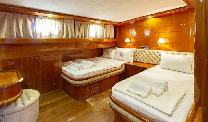 Interior of Silver Moon cabin with two single beds and warm wood paneling