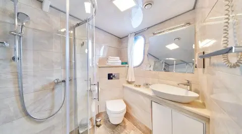 Casablanca yacht interior: sleek marble counters, white cabinets, and bathroom with glass shower