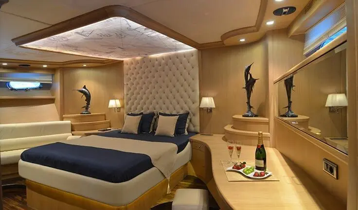 Interior of Blue Heaven yacht cabin with bed, seating, and warm lighting