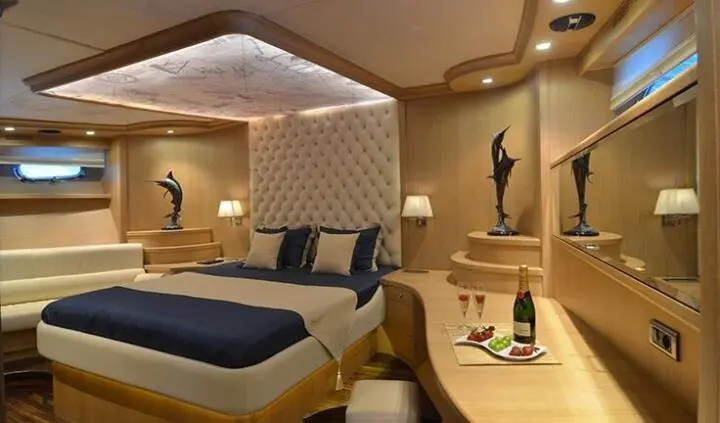 Interior of Blue Heaven yacht cabin with bed, seating, and warm lighting