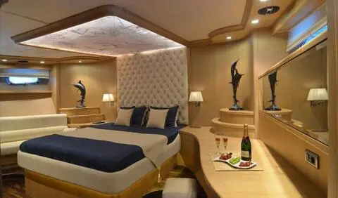 Interior of Blue Heaven yacht cabin with bed, seating, and warm lighting