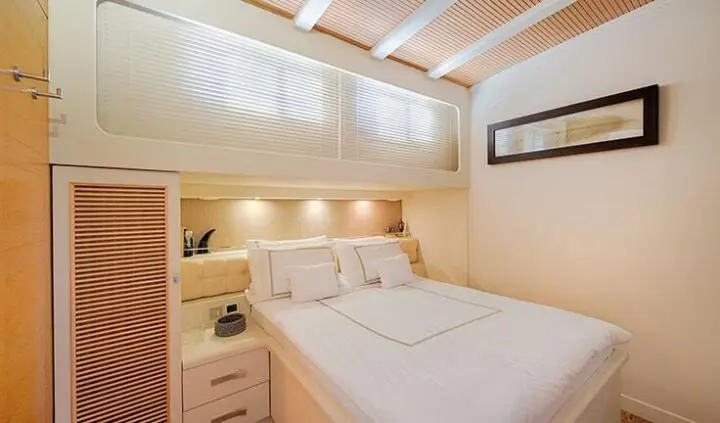 Cobra King yacht cabin with a large bed, bedside tables, and soft lighting
