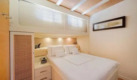 Cobra King yacht cabin with a large bed, bedside tables, and soft lighting