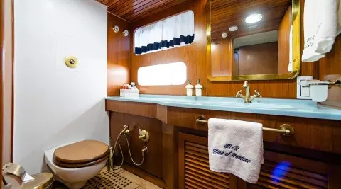 Luxurious yacht Wind Of Fortune deck with polished wood, window, and sink area at sunset