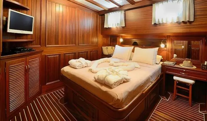 Zephyria II cabin with two single beds pushed together, wood-paneled interior