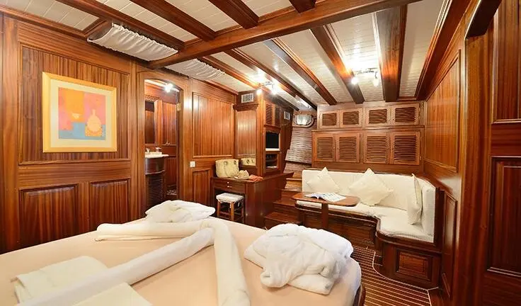 Zephyria II cabin with two beds, wood paneling, and beige bedding, cozy lighting