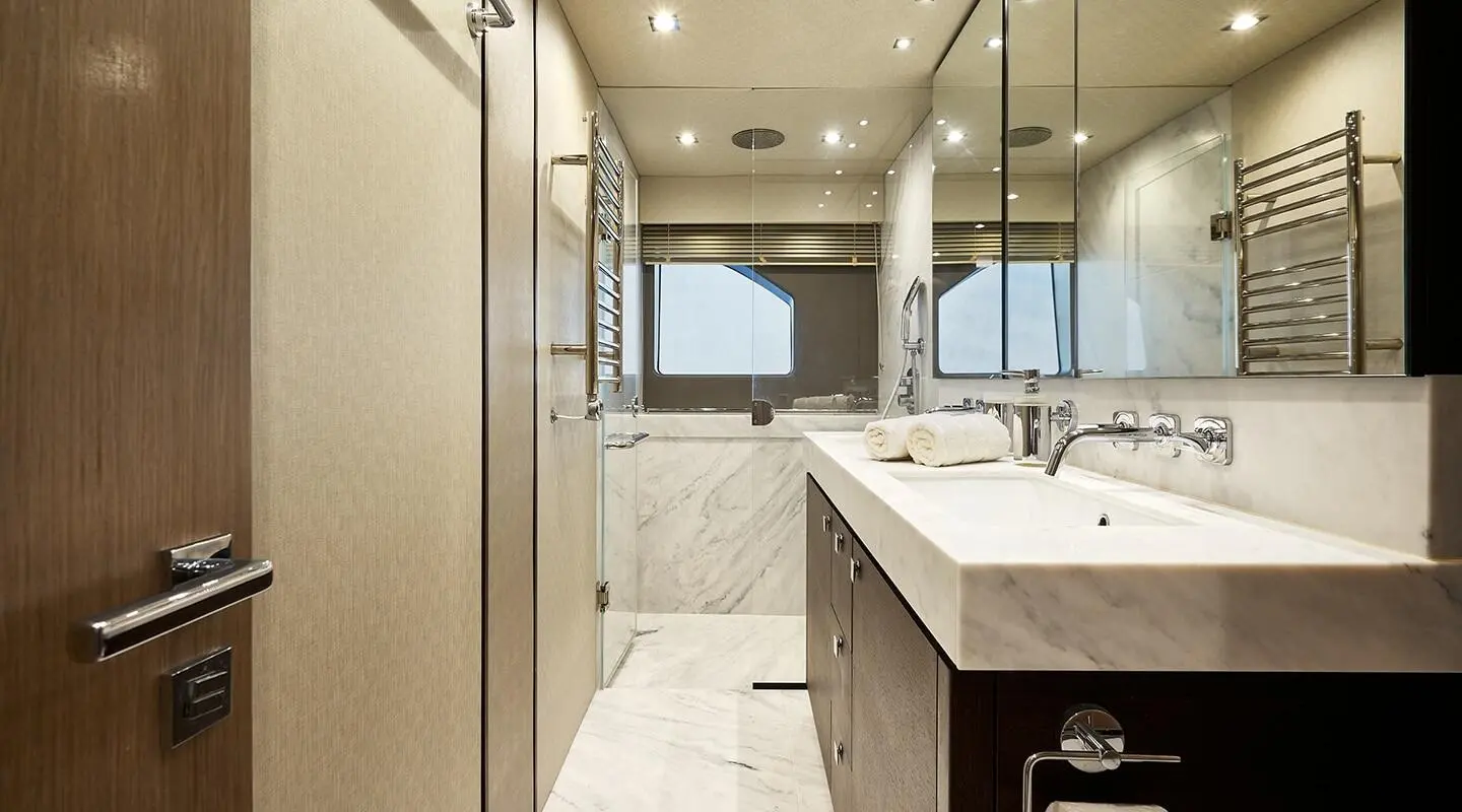 Luxurious yacht bathroom with marble surfaces, spacious vanity, and polished fixtures