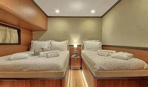 Queen Of Salmakis cabin with triple beds, warm wood accents and seating