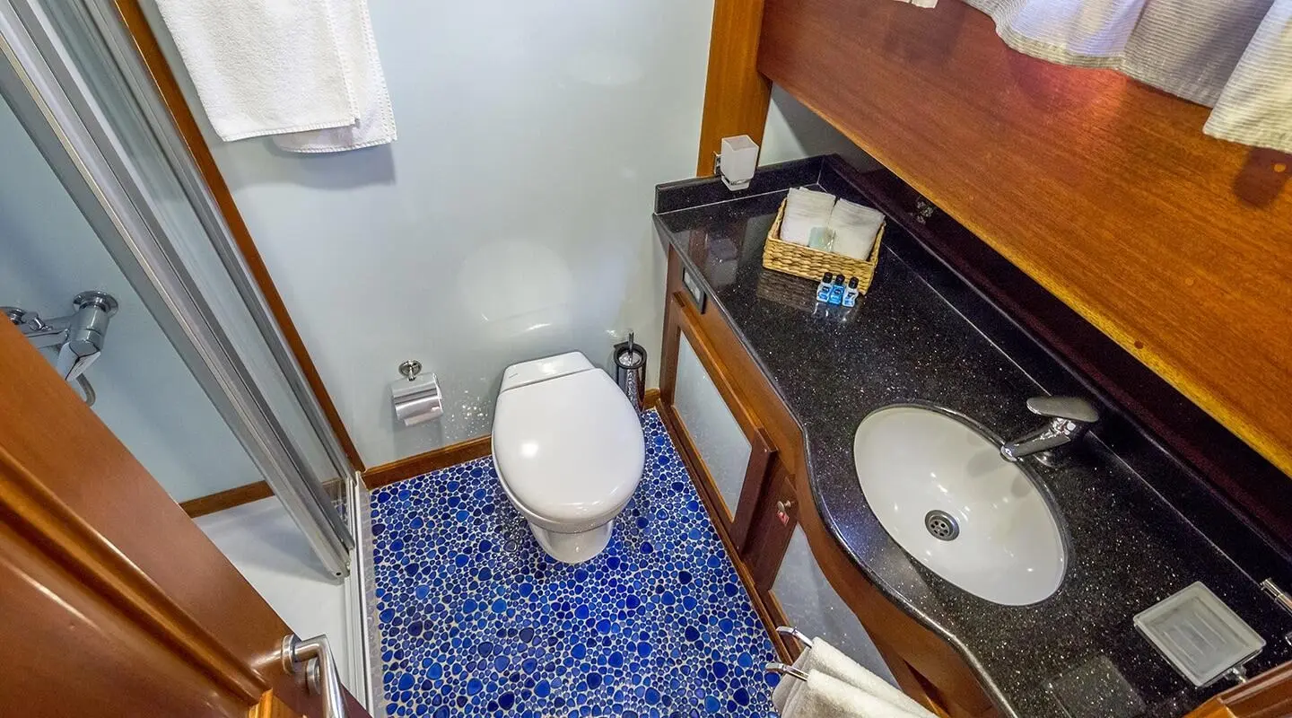 Luxurious yacht interior with wooden cabinets, blue patterned countertop, and sink.