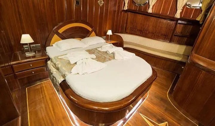 Master cabin with king bed and ensuite, wood paneling, bedside lamps