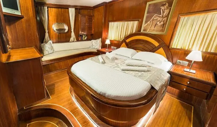 Diva Deniz master cabin with king bed, plush wood panels, ensuite bath visible