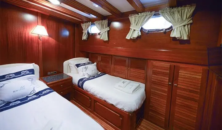 Yacht Ros Mare cabin with twin beds and wood cabinetry interior