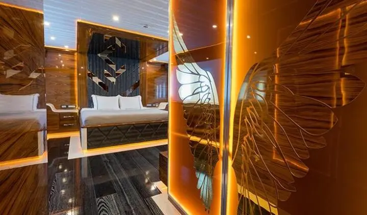 Master cabin with king bed and ensuite on a yacht, wood panels and cabin decor