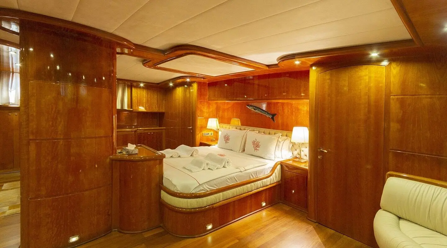 Luxurious interior cabin aboard Silver Moon; warm wood panels, bed, and soft lighting