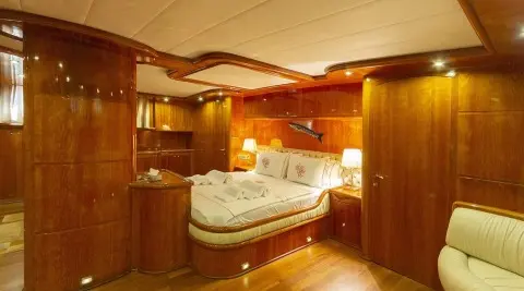 Luxurious interior cabin aboard Silver Moon; warm wood panels, bed, and soft lighting