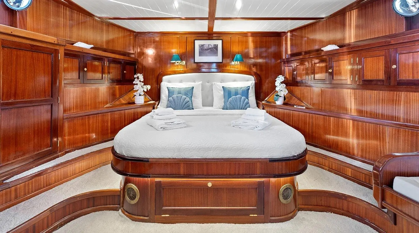 Luxurious yacht cabin with large bed and rich wood panels