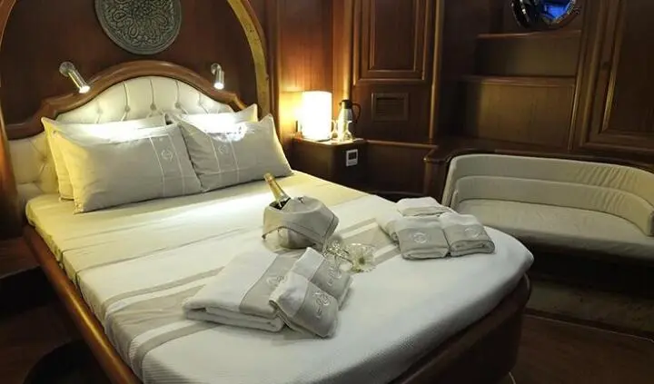 Master cabin with king bed, plush bedding, and ensuite layout on yacht