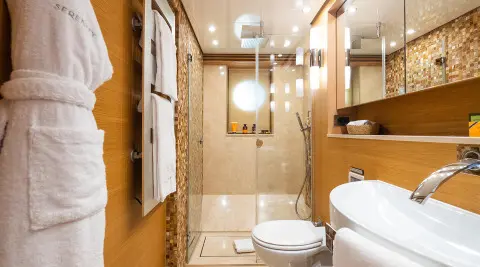 Exterior of Serenity yacht with wooden deck, seating, and ocean backdrop