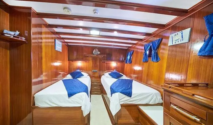 Twin cabin on Stella Maris yacht with two single berths and wood paneling