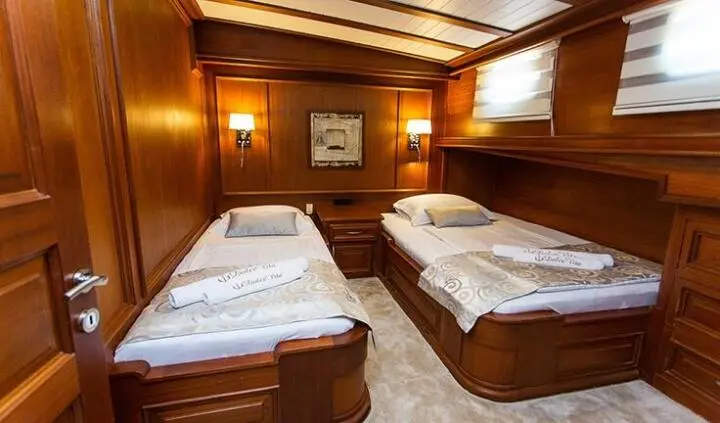 Dolce Vita twin cabin with two single beds, wooden panels, and ensuite area