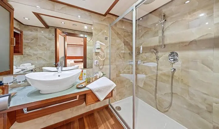 Master cabin with king bed and ensuite shower area on Alessandro I yacht