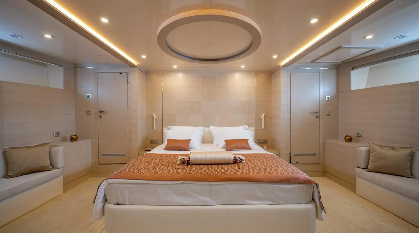 Luxurious yacht Love Story interior with bed, warm lighting, cream walls